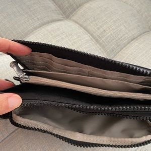 Black wristlet with 3 pockets. Credit card slots and count pocket.